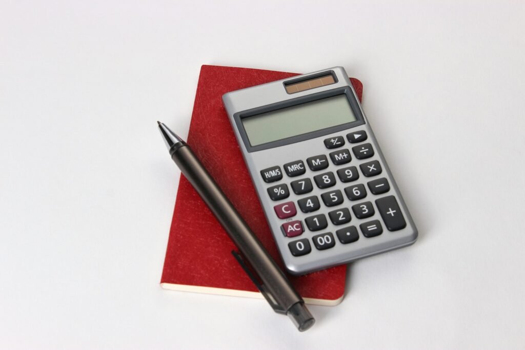 black and silver calculator beside black pen